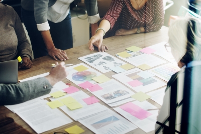 Conference table with a group of people collaborating on paperwork.